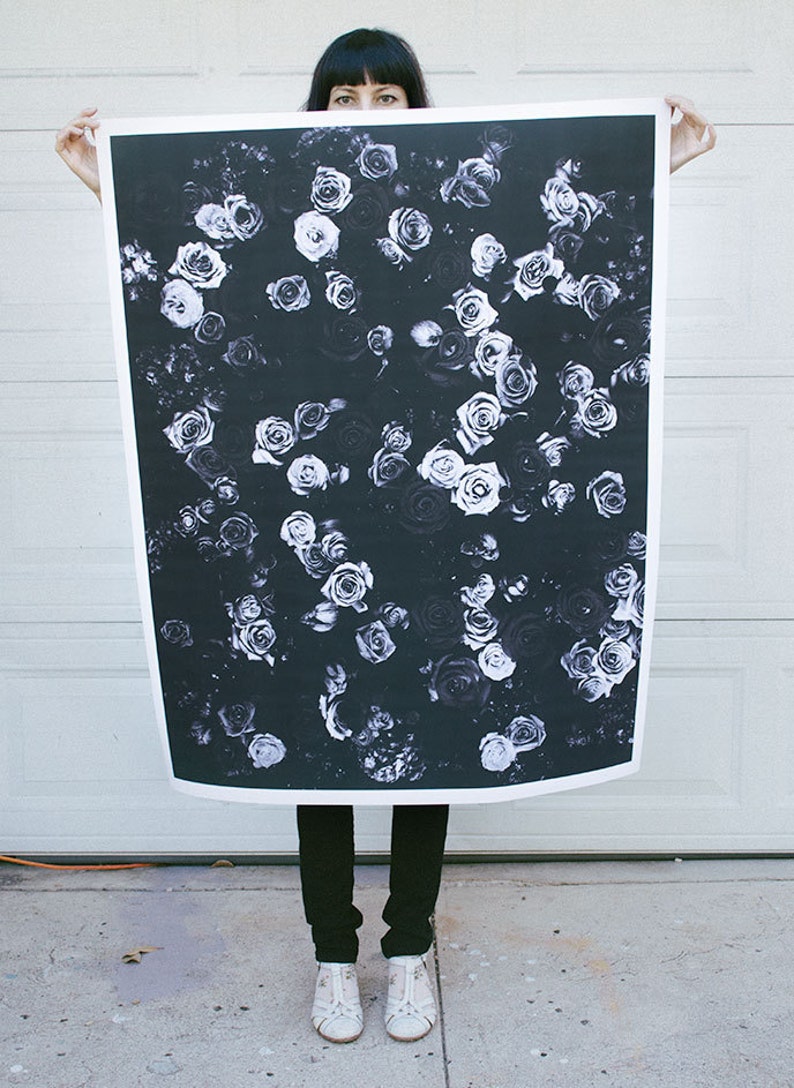 May include: A black and white photograph of a floral pattern featuring many roses. The roses are arranged in a random pattern and appear to be in bloom. The background is a dark, almost black, color.