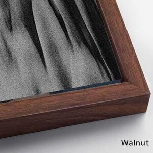Puede incluir: Una obra de arte enmarcada con acabado de nogal. El marco rodea una obra de arte con tonos grises y negros. La palabra "Walnut" est&aacute; impresa en la esquina inferior derecha.