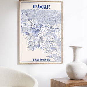 Pu&ograve; includere: Una stampa di mappa in stile vintage di Los Angeles, California, in inchiostro blu su sfondo bianco. La mappa mostra le strade, i quartieri e i punti di riferimento della citt&agrave;. Il titolo "Los Angeles" e "California" sono stampati in blu nella parte superiore e inferiore della mappa.