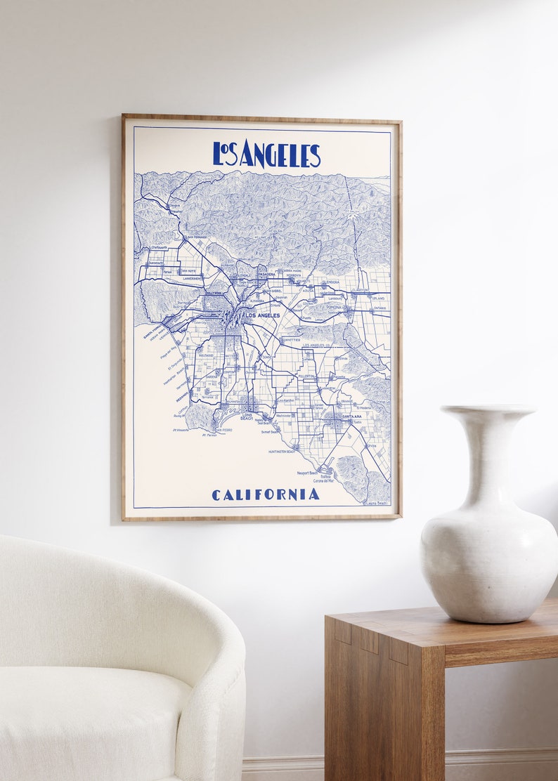 Pu&ograve; includere: Una stampa di mappa in stile vintage di Los Angeles, California, in inchiostro blu su sfondo bianco. La mappa mostra le strade, i quartieri e i punti di riferimento della citt&agrave;. Il titolo "Los Angeles" e "California" sono stampati in blu nella parte superiore e inferiore della mappa.