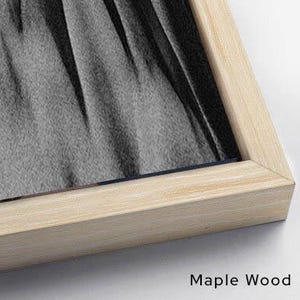 Puede incluir: Una obra de arte enmarcada con un marco de madera de arce natural. La obra presenta una imagen en escala de grises de tela drapeada. El texto "Maple Wood" est&aacute; impreso en negro en la esquina inferior derecha.