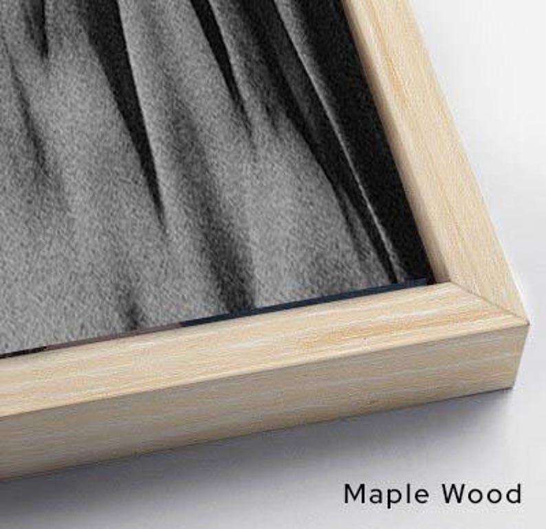 Puede incluir: Una obra de arte enmarcada con un marco de madera de arce natural. La obra presenta una imagen en escala de grises de tela drapeada. El texto "Maple Wood" est&aacute; impreso en negro en la esquina inferior derecha.