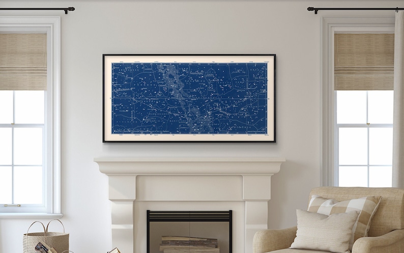 Puede incluir: Un mapa vintage enmarcado de constelaciones impreso en blanco sobre un fondo azul oscuro. El mapa est&aacute; colgado sobre una repisa de chimenea blanca.