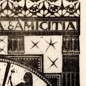 May include: A black and white woodcut print of a woman holding a staff. The print is framed by a decorative border with the text "& AMICITIA" at the top. The background features a repeating pattern of stars.