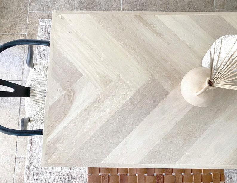 White oak wood table with herringbone pattern. Chair and bench around the table.