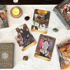 May include: An arrangement of tarot cards, crystals, candles, and books. The tarot deck is titled "Enchanted For Haxa Tarot" by MJ Cullinane. The cards feature colorful illustrations. Other items include a sage bundle, and small bottles.