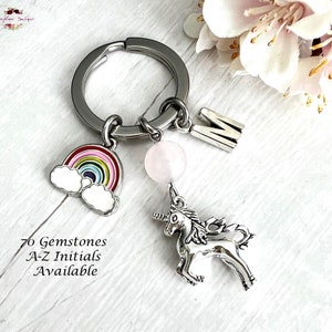 May include: A silver keychain with a rainbow charm, a pink gemstone bead, a silver unicorn charm, and a silver letter M charm. 70 Gemstones A-Z Initials Available.