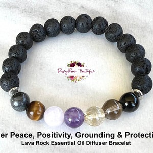 May include: A black lava rock essential oil diffuser bracelet with silver beads and various gemstone beads, including tiger's eye, amethyst, clear quartz, and smoky quartz. The bracelet is labelled "Inner Peace, Positivity, Grounding & Protection".