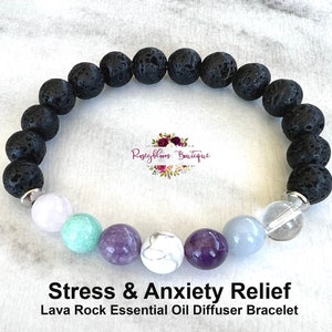 May include: Black lava rock essential oil diffuser bracelet with amethyst, clear quartz, white howlite, lavender amethyst, and aquamarine beads. "Stress & Anxiety Relief" and "Lava Rock Essential Oil Diffuser Bracelet" are written below the bracelet.