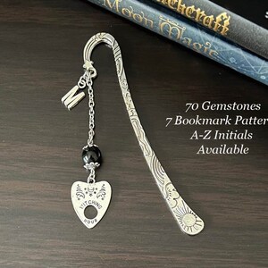 Puede incluir: Marcapáginas de plata con un amuleto de la hora de la bruja, una cuenta negra y la letra M. 70 gemas, 7 patrones de marcapáginas, iniciales A-Z disponibles.
