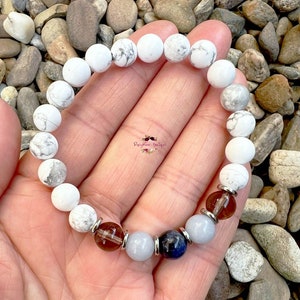 May include: White Howlite beaded bracelet with brown, blue, and light blue accent beads.