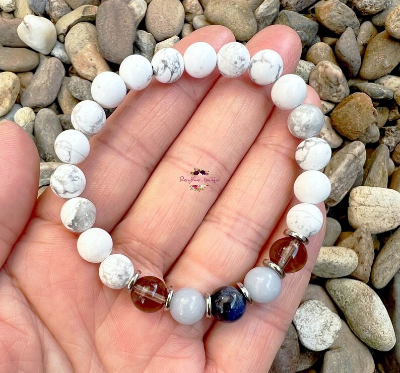 May include: White Howlite beaded bracelet with brown, blue, and light blue accent beads.