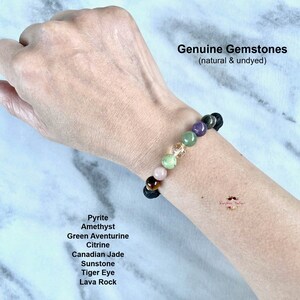 Puede incluir: Un brazalete hecho con piedras preciosas naturales, incluyendo pirita, amatista, aventurina verde, citrino, jade canadiense, piedra de sol, ojo de tigre y roca volc&aacute;nica. El brazalete est&aacute; en la mu&ntilde;eca de una persona. Gemas genuinas (naturales y sin te&ntilde;ir).