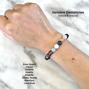 May include: A bracelet made with genuine gemstones, including rose quartz, citrine, sodalite, howlite, angelite, smoky quartz, amethyst, and lava rock. The bracelet is on a person's wrist. Genuine Gemstones (natural & undyed)