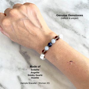 May include: A bracelet made with genuine gemstones, including sodalite, angelite, smoky quartz, and howlite. The bracelet is on a person's wrist and is described as a sample bracelet for women in size XS. The text "Genuine Gemstones (natural & undyed)" is also visible in the image.