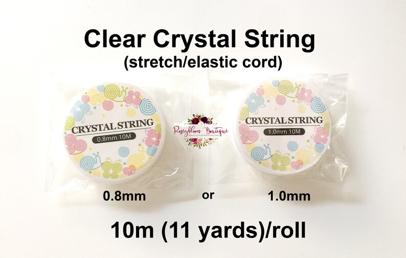 May include: Two rolls of clear elastic cord, labeled "Crystal String" in white text on a colorful background. The rolls are 0.8mm and 1.0mm thick and each roll is 10 meters (11 yards) long.