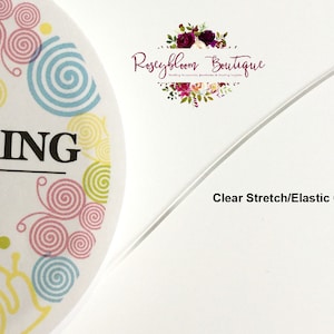 May include: Clear stretch elastic cord, also known as string, for crafts and jewelry making. The cord is white and is shown on a white background.
