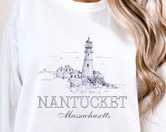 Könnte beinhalten: Weißer Langarm-Pullover mit einem blauen und weißen Grafikdruck eines Leuchtturms und dem Text "NANTUCKET Massachusetts".
