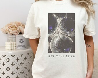 May include: White t-shirt with a graphic of silver disco balls and the text "NEW YEAR DISCO"