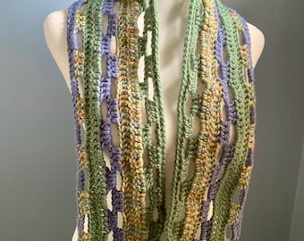 The Meadow scarf, open weave scarf in Nature’s colors of green, blue and brown. Lightweight scarf to wrap your neck.