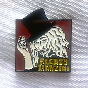 Könnte beinhalten: Quadratischer Emaille-Pin mit einer Cartoon-Illustration eines Mannes mit langen weißen Haaren, einem schwarzen Zylinder und einem Schnurrbart. Der Mann hält eine Münze mit der Aufschrift "SEXY". Die Worte "SLEAZY MANZINI" sind in goldfarbenen Buchstaben geschrieben.
