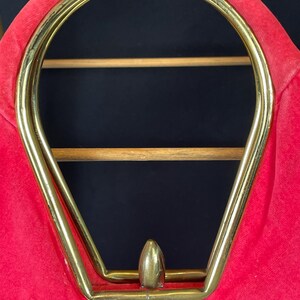 May include: A red velvet handbag with a gold metal frame and a gold metal top handle.