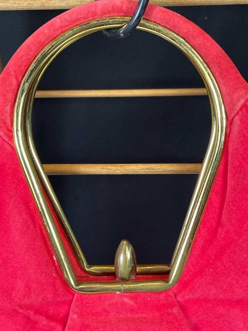May include: A red velvet handbag with a gold metal frame and a gold metal top handle.