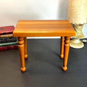 Puede incluir: Una taza de cerámica blanca con asa negra y el texto "But First, Coffee" en negro, con una fuente de estilo manuscrito. La taza está sobre una superficie blanca.