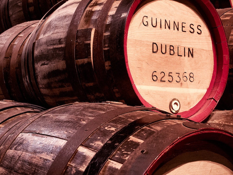 Puede incluir: Barriles de madera apilados con bandas met&aacute;licas, el barril superior est&aacute; etiquetado con "GUINNESS DUBLIN 625368".