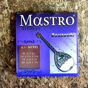 Puede incluir: Un paquete morado y blanco de cuerdas de bouzouki Mastro. El paquete muestra un bouzouki plateado con un diseño verde. El texto del paquete dice "Mastro Strings 0.11 Nickel RE 0.17 0.11 LA 0.14 0.14 FA 0.22 0.10 DO 0.28 0.12 Bouzouki"