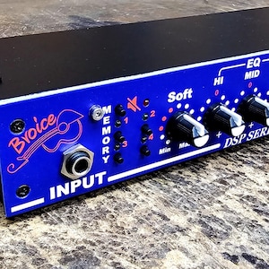 May include: A black and blue DSP Series audio effects processor. The device has multiple knobs and input jacks, with text that reads "Broice" and "INPUT". The top is black, and the front panel is blue with white lettering. The device is rectangular.