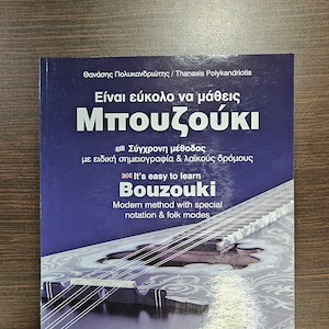 May include: A blue book cover with the title "It's easy to learn Bouzouki" in white text. The book cover also features a photo of a bouzouki, a Greek musical instrument, and the text "Modern method with special notation & folk modes".