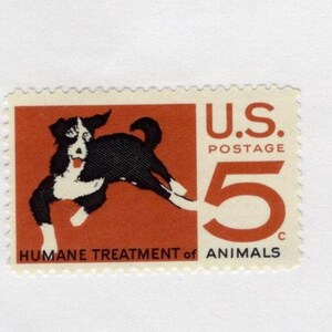 May include: A vintage U.S. postage stamp featuring a black and white dog leaping against a red background. The stamp reads "U.S. Postage 5c" and "Humane Treatment of Animals."