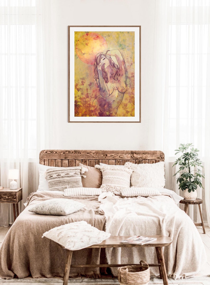 May include: A framed watercolour painting of a nude woman with long, flowing hair, standing in a field of flowers. The background is a soft yellow with hints of pink and purple.