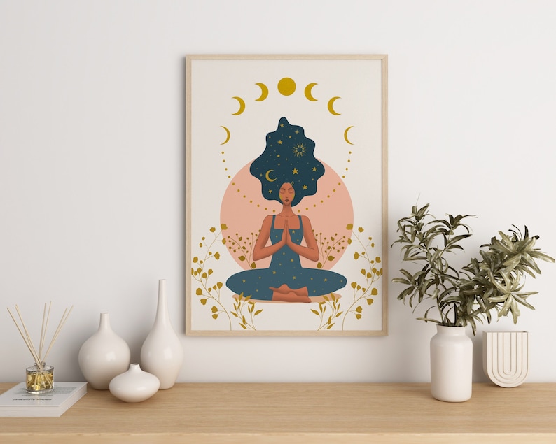 May include: A framed illustration of a woman meditating with her eyes closed. Her hair is dark blue and filled with stars. The background is a peach color with gold crescent moons and stars.