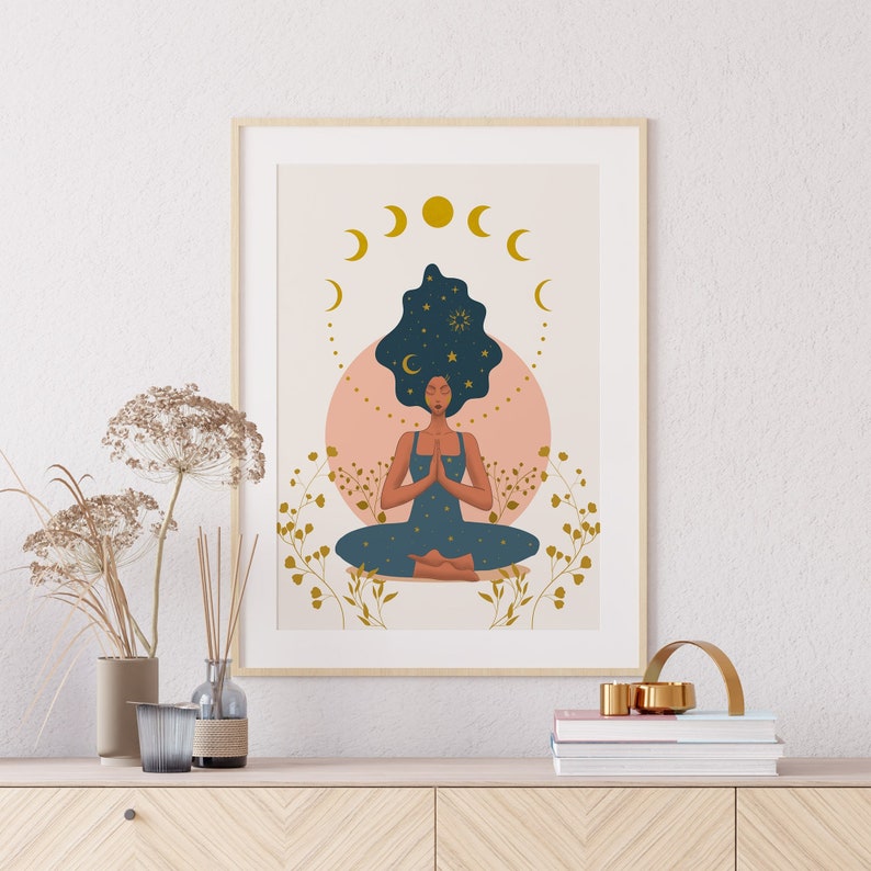 May include: A framed illustration of a woman meditating with her eyes closed. Her hair is blue and filled with stars. She is surrounded by a pink circle and gold crescent moons.