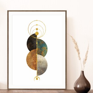 May include: Abstract geometric art print with three overlapping circles in shades of brown, blue, and gray. A gold line runs vertically through the center of the circles, with smaller gold circles along the line. The print is framed in a brown wood frame.