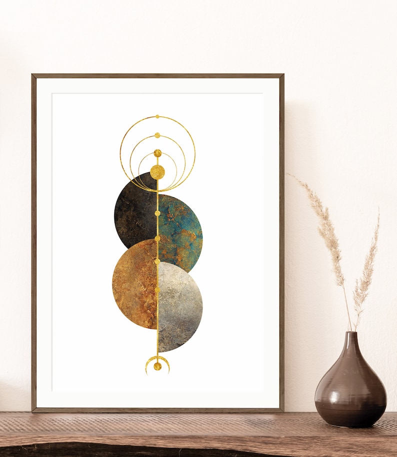 May include: Abstract geometric art print with three overlapping circles in shades of brown, blue, and gray. A gold line runs vertically through the center of the circles, with smaller gold circles along the line. The print is framed in a brown wood frame.