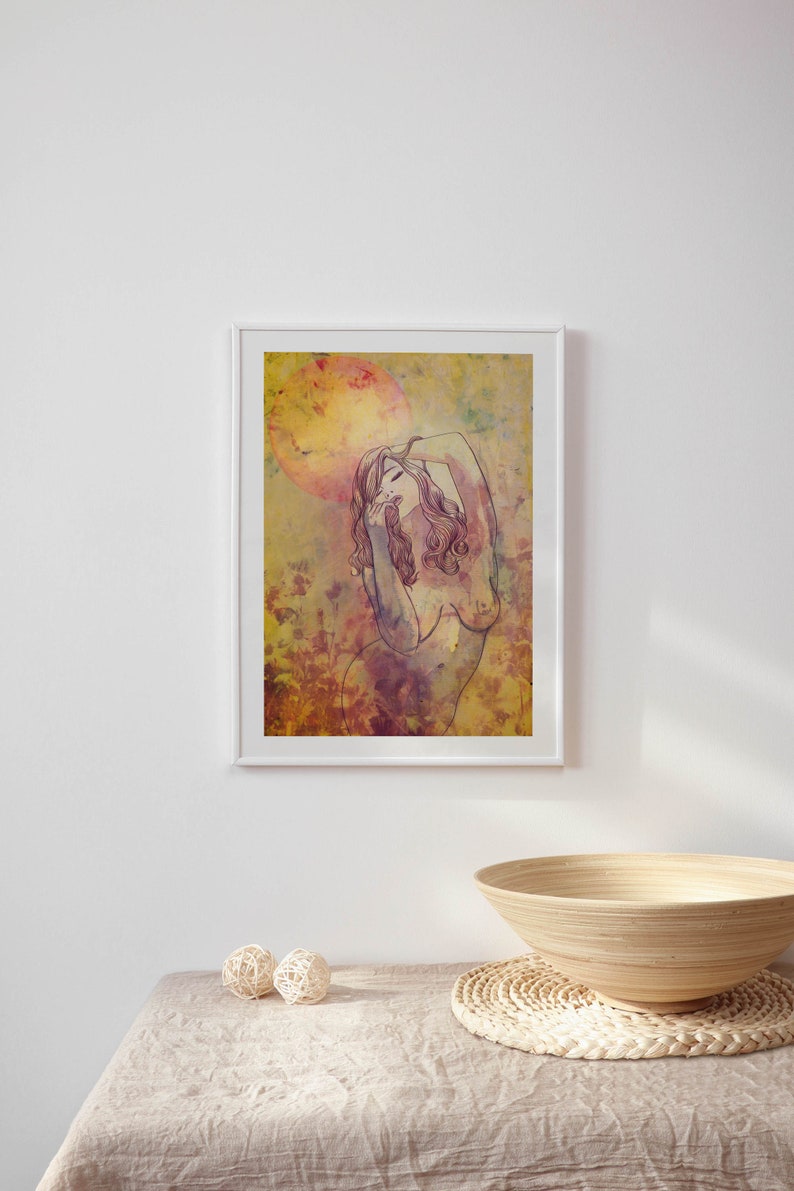 May include: A framed print depicting a woman with long hair, standing in a field of flowers. The background is a watercolour wash of yellow, orange, and pink.