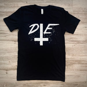 May include: Black t-shirt with a white graphic of the word "DIE" with a stylized inverted cross.