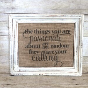 May include: A white framed burlap canvas with the text "The things you are passionate about are not random, they are your calling." printed in black.
