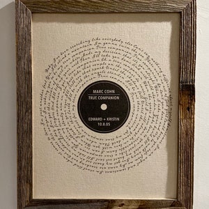 Puede incluir: Una impresi&oacute;n enmarcada de una letra de canci&oacute;n con un dise&ntilde;o en forma de disco. La letra est&aacute; escrita a mano y el disco presenta el t&iacute;tulo de la canci&oacute;n "True Companion" de Marc Cohn, los nombres "Edward + Kristin" y la fecha "10.8.05".