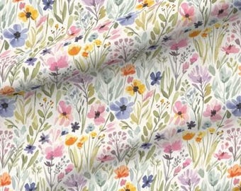 May include: Watercolor floral fabric featuring a repeating pattern of colorful wildflowers. The design includes pink, blue, yellow, and orange flowers with green foliage on a cream background. The fabric is suitable for various craft and sewing projects.