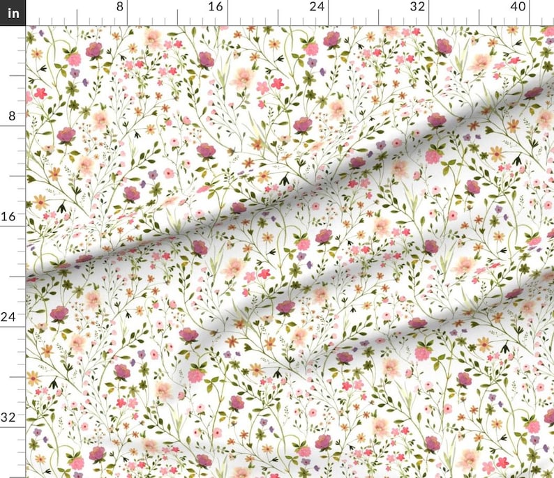 May include: A fabric with a white background featuring a watercolor floral pattern. The design includes pink, purple, and peach-colored flowers, along with green leaves and stems. The pattern is a repeating design.