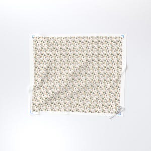 May include: A white fabric with a repeating pattern of small, stylized trees, houses, and other objects in shades of green, brown, and beige. The pattern is densely packed across the fabric's surface.