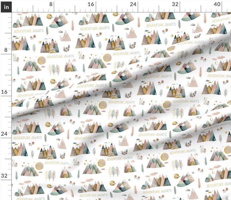 May include: White fabric with a repeating pattern of watercolor mountains, clouds, stars, moons, and trees. The mountains are in shades of pink, blue, green, and brown. The text 'Adventure Awaits' is repeated throughout the pattern in a gold color.