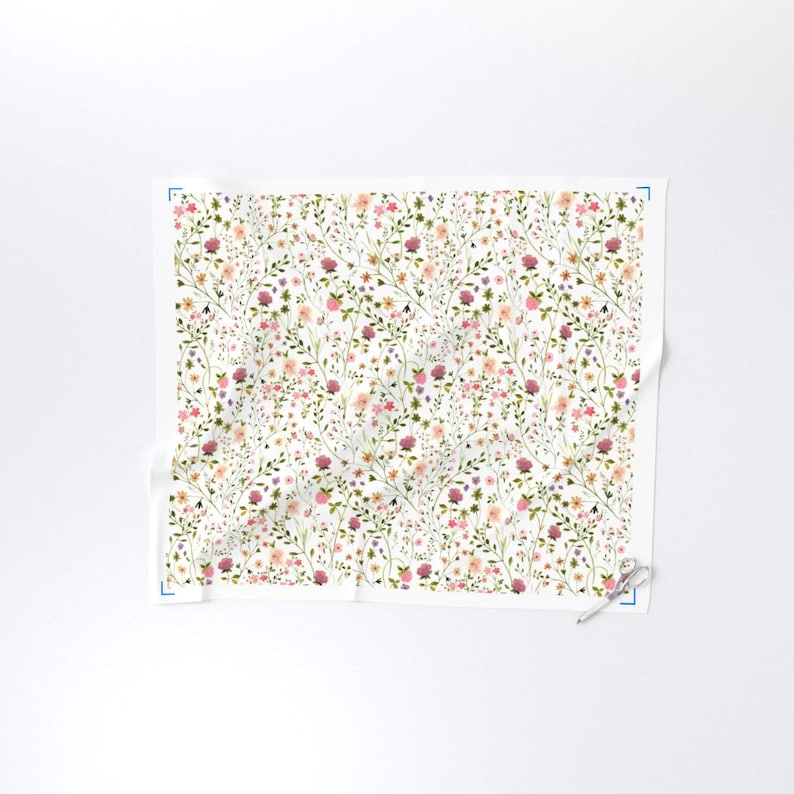 May include: A white fabric with a delicate floral pattern. The design features a repeating pattern of small flowers in shades of pink, purple, and yellow, along with green leaves and stems. The overall effect is a soft, watercolor-like aesthetic.