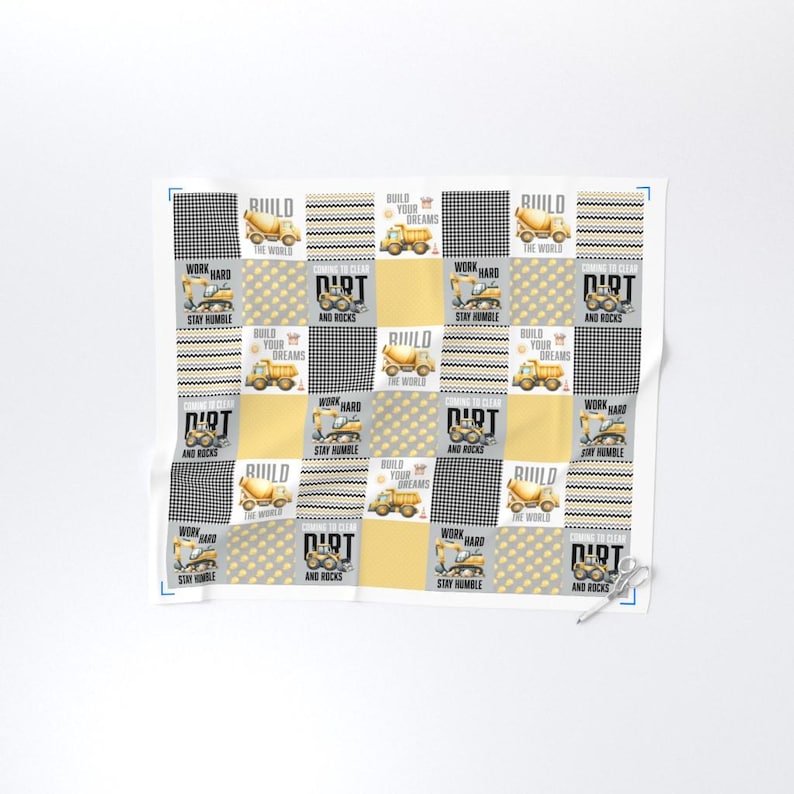 May include: A white and yellow patchwork design featuring construction vehicles, including cement mixers and dump trucks. The design includes the words "Build Your Dreams", "Work Hard", "Dirt and Rocks", and "Stay Humble".