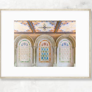 May include: Three arched doorways with colorful mosaic tile designs in a building with a white ceiling.