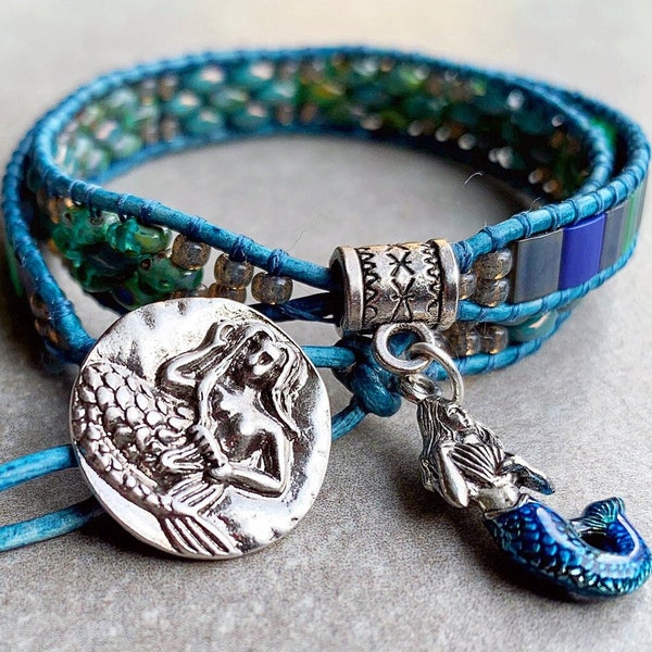 Mermaid Button fastens 2 Leather Wrap bracelet with wavy colors of blues, aquamarine and silver with Mermaid Charm separating the 2 sections